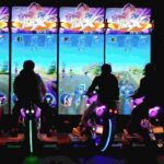 three players using motorcycle arcade machines